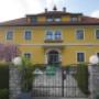 Außenansicht Pilgramhof in Friesach, Kärnten: gelbes Bauernhaus mit Garten & Eingangstor – ideal für Urlaub am Bauernhof Friesach, Ferienwohnungen Kärnten und Ferienwohnung mieten Kärnten.