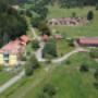 Luftaufnahmen vom Pilgramhof in Friesach: Bauernhof mit Wohnhaus, Stallungen und Wiesen am Waldrand – perfekt für Urlaub am Bauernhof Kärnten & Ferienwohnungen Kärnten.