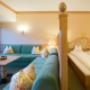 Komfortdoppelzimmer im Sonnenburg Landhaus mit Doppelbett und grüner Sofalandschaft Komfortdoppelzimmer im Sonnenburg Landhaus mit Doppelbett und grüner Sofalandschaft