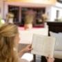 Lesender Gast in Lounge auf Sonnenterrasse vor Hoteleingang zum Hotel Sonnenburg