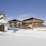 Außenansicht Familienhotel Sonnenburg im Winter mit blauem Himmel und im Vordergrund die Kapelle der Sonnenburg inmitten der Skipiste Außenansicht Familienhotel Sonnenburg im Winter mit blauem Himmel und im Vordergrund die Kapelle der Sonnenburg inmitten der Skipiste