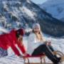 Kinder auf Rodel in Winterlandschaft Kinder auf Rodel in Winterlandschaft