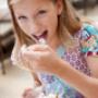 Kind beim Eis essen auf Sonnenterrase