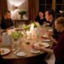 Festliches Abendessen an ovalem Tisch mit mehreren Gästen Festliches Abendessen an ovalem Tisch mit mehreren Gästen