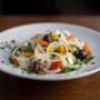 Knackiger Gemüsesalat im Restaurant Galaxie Wien mit Tomaten, Paprika, Zwiebeln, Oliven und frischen Kräutern. Leichte, gesunde Vorspeise für Genießer mediterraner Küche.