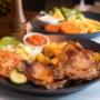 Traditionelles Grillgericht im Restaurant Galaxie Wien: Saftiges Fleisch mit Bratkartoffeln, frischem Salat und Ajvar. Authentische Balkan-Spezialität für Liebhaber herzhafter Küche.