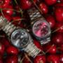 Eine Nahaufnahme derselben Rolex-Paarung: die kühle Raffinesse des grauen Zifferblatts und die leidenschaftliche Tiefe des roten Modells betonen die Vielseitigkeit der Day-Date-Kollektion.