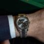 Am Handgelenk getragen, wirkt die Rolex Day-Date mit grauem Zifferblatt zeitlos elegant. Der Kontrast zwischen dem dunklen Ärmel und dem Glanz des Edelmetalls verleiht dem Bild eine klassische Business-Note.