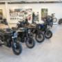 Reihe von Husqvarna Motorrädern im hellen Store, Zubehör an der Wand – dein Husqvarna Händler & Bikeshop in Wien für Motorradzubehör.