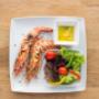 Frische Meeresfrüchte im Freihausviertel: Perfekt gegrillte Riesengarnelen mit Salat. Genießen Sie traditionelle portugiesische Küche in modernem Ambiente.
