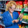 Eine Dame liest im Supermarkt die Details mithilfe einer Licht-Lupenbrille von VIDEBIS