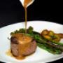 Saftig gebratenes Steak mit Sauce, Spargel und Kartoffeln im Restaurant Südufer Guntramsdorf – mediterran inspiriertes Hauptgericht, frisch zubereitet mit Fokus auf regionale und saisonale Küche.