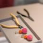 Handwerk im Fokus: Bunte Ohrringe und Werkzeuge für Schmuck mit Gravur und individuelle Anpassungen im Wiener Atelier von MAX Schmuckdesign.