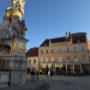 Außenbereich des Cafe Central mit Blick auf den historischen Platz und die beeindruckende Dreifaltigkeitssäule - ein stimmungsvolles Ambiente mitten in Baden