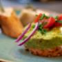 Feine Avocado-Vorspeise mit frischen Kräutern, Tomaten und Zwiebeln im Bummelhof auf der Mariahilfer Straße. Moderne urbane Küche Wien mit regionalen Zutaten im gemütlichen Restaurant.