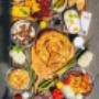 Vielfältige Balkan Frühstücksplatte mit Burek, Ćevapčići, gegrilltem Fleisch, Käse, Eiern, frischem Gemüse, Ajvar und Pita – die größte Auswahl an balkanischen Spezialitäten in Wien.