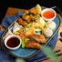 Unsere Snack-Platte: Knuspriges Popcorn Chicken asiatisch, handgemachte asiatische Teigtaschen und Frühlingsrollen. Die ideale Wahl für taiwanesische Tapas-Liebhaber und Fans von modernem asiatischem Streetfood.