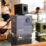 Design-Mehrfachsteckdose Avolt Square 1 in Schwarz und Oliv. Praktischer Power Extender in Würfelform mit USB-Anschlüssen, magnetischem Fuß und modernem skandinavischem Design – ideal für Schreibtisch oder Wohnzimmer.