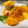 Klassiker in Wien: Goldbraunes Schnitzel mit Pommes und Zitrone. Günstiges Mittagsmenü in bester Qualität im Kafe'de Bistro – auch zum Mitnehmen (Takeaway).