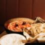 Klassisches Butter Chicken mit frischem Naan-Brot. Authentisch indisch genießen bei Jarita's Indian Kitchen oder über unseren indischen Lieferservice bequem nach Hause bestellen.