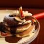 Luftige Pancakes im Café Bellaria Wien, getoppt mit Banane & frischen Feigen, überzogen mit hausgemachter Schokosauce. Perfekt für Frühstück, Brunch & Dessert im 1. Bezirk.