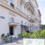 Straßenansicht des Café Bellaria, Bellariastraße 6, 1010 Wien: Gäste im Schanigarten, große Rundbogenfenster und elegante Fassade – Wiener Kaffeehaus für Frühstück, Mittag & Bar am Abend.