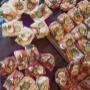 Vielfältig belegte Brötchen mit Käse, Wurst, Schinken und buntem Gemüse, dekoriert mit Eiern, Gurken, Paprika und frischen Kräutern. Perfekt für Buffets, Feiern und kulinarische Events in gemütlicher Atmosphäre.
