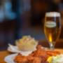 Backhendl mit Kartoffelsalat und Zitrone – goldbraun, knusprig und perfekt abgestimmt mit einem frisch gezapften Bier im Bieriger Wien.