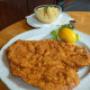 Knuspriges Wiener Schnitzel mit Zitronenscheibe und Kartoffelsalat – ein Klassiker der österreichischen Küche im Bieriger Wien.