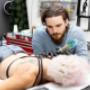 Tattoo-Artist Robert bei der Arbeit an einem Rücken-Tattoo im Happy Needles Tattoo Studio Wien. Die Aufnahme unterstreicht die Präzision, Kreativität und Professionalität, für die Robert und das Studio bekannt sind.