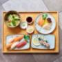 Sushi- und Maki-Kombination mit Salat und Sashimi – frisch zubereitet im Koinonia+ in Wien.
