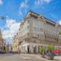 Hier sieht man das Restaurant Koinonia+ an einer sonnigen Straßenecke in Wien. Die helle Fassade und die ruhige Lage machen das Lokal zum idealen Ort für asiatische Küche mit koreanischem Schwerpunkt.