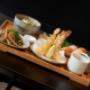 Japanisches Bento mit Tempura-Garnelen, Wok-Beef, Sushi und Beilagen – Koinonia+ asiatisches Restaurant Wien.