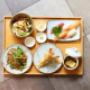 Bento-Set von oben: Tempura, Nudeln, Salat, Sushi & Beilagen – japanische Küche im Koinonia+ Wien.