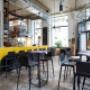 Das moderne Sitzarrangement mit farbigen Sesseln, klaren Linien und stilvoll gedeckten Tischen macht das asiatische Restaurant Wien Koinonia+ zum idealen Treffpunkt für kulinarische Genüsse in exklusivem Ambiente.