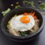 Traditionelles koreanisches Bibimbap im heißen Stein mit Ei und Gemüse – Koinonia+ Wien.