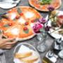 Italienische Spezialitäten in der Trattoria Margareta: knusprige Pizza, Antipasti und frisches Brot im gemütlichen Gastgarten im Schlossquadrat Wien – ideal zum Essen mit Freunden und Familie.