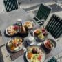 Reichhaltige Frühstücksauswahl mit Käse- und Schinkenplatten, Eierspeisen, frischem Brot, Müsli und Kaffee im hellen Gastgarten des Café-Restaurant Resselpark Wien – klassischer Start in den Tag nahe Karlsplatz.