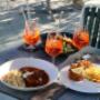 Servierte Hauptgerichte mit Beilagen und Getränken im Gastgarten des Café-Restaurant Resselpark Wien – Wiener Küche und Aperitifs in sonniger Parklage nahe Karlsplatz.