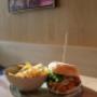 Burger mit knusprigem Patty, frischem Salat und Pommes frites im Café-Restaurant Resselpark Wien – frisch serviertes Gericht in gemütlicher Innenatmosphäre, ideal für ein entspanntes Mittagessen nahe Karlsplatz.