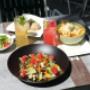 Servierter Salat mit Beilagen und Getränken im Außenbereich des Café-Restaurant Resselpark – leichte Küche und entspanntes Essen im Gastgarten nahe der Karlskirche.