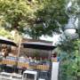 Belebter Gastgarten mit schattigen Sitzplätzen, Sonnenschirmen und Blick auf das Prater-Geschehen – ideal für eine entspannte Auszeit bei Kaffee, Brunch oder kleinen Speisen.