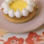 Zitronentarte mit Baiser auf Dessertteller im Ponykarussell Wien. Frisches Dessert für Café-Besuch, Patisserie-Genuss und süße Momente im Wiener Prater.