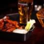 Knusprige Chicken Wings mit Dip und ein kühles Cider im Trinity Pub Vienna – die gemütliche Bar mit warmer Küche und feinstem Irish Pub Essen in Wien.